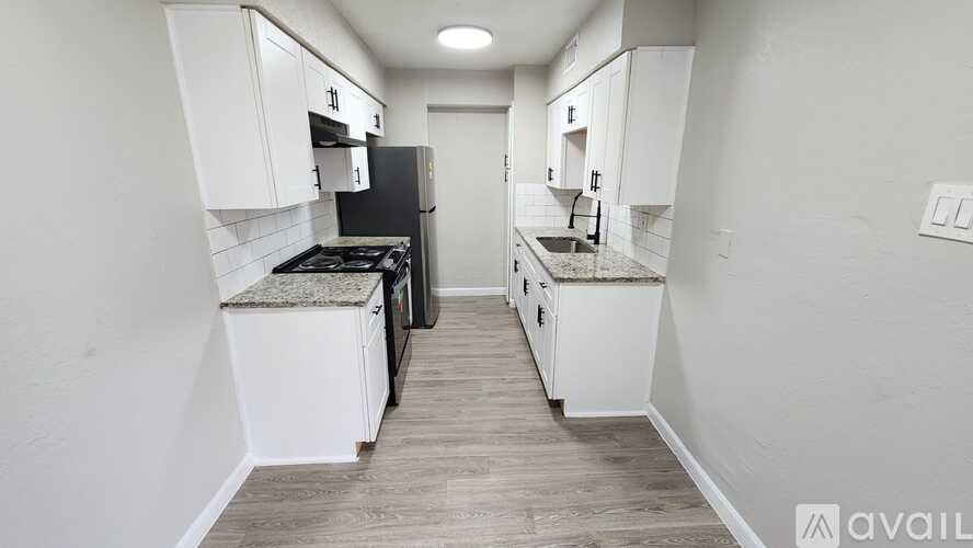 A kitchen with white cabinets and a black stove top oven.