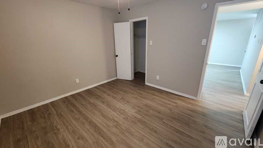 A room with a wooden floor and a white door.