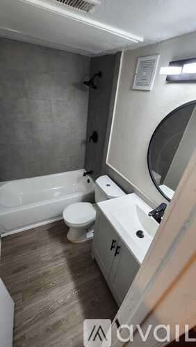 A bathroom with a toilet, sink, and mirror.