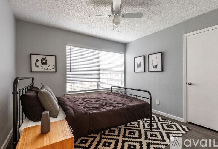 A bedroom with a bed, a ceiling fan, and a rug.