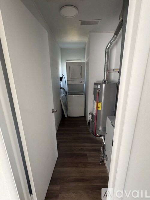 A narrow hallway with a refrigerator and a furnace.