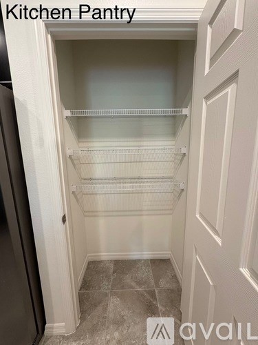 A kitchen pantry with a refrigerator on the left and shelves on the right.