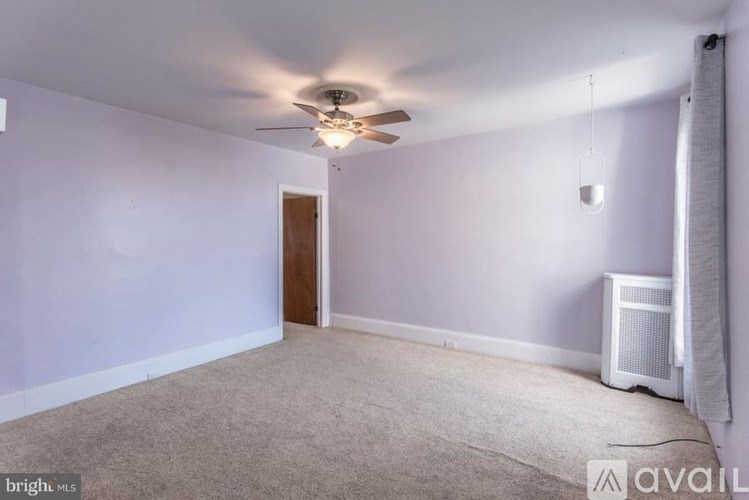 A room with a ceiling fan and a carpeted floor.