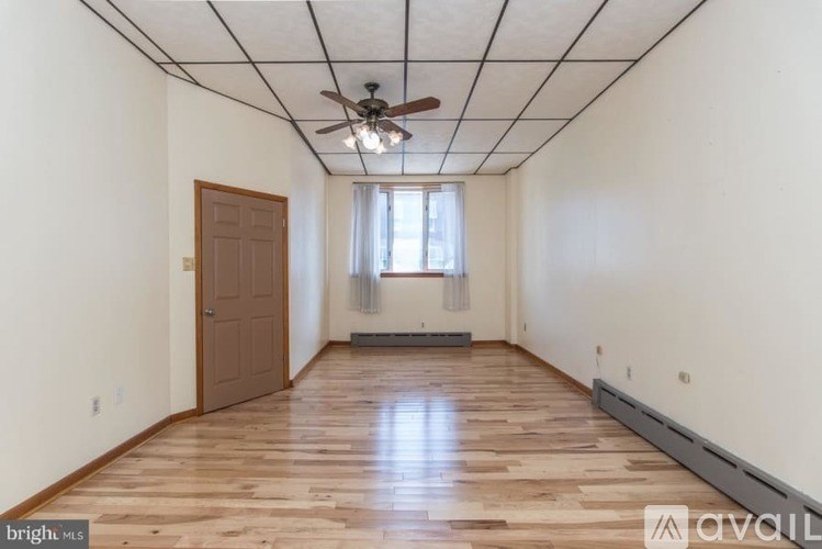 A room with wooden floors and a ceiling fan.