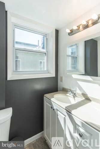 A bathroom with a white toilet, a sink, and a window.