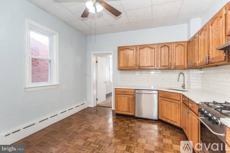 A kitchen with wooden cabinets and a white dishwasher.