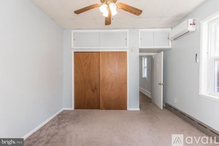 A room with a ceiling fan and a door.