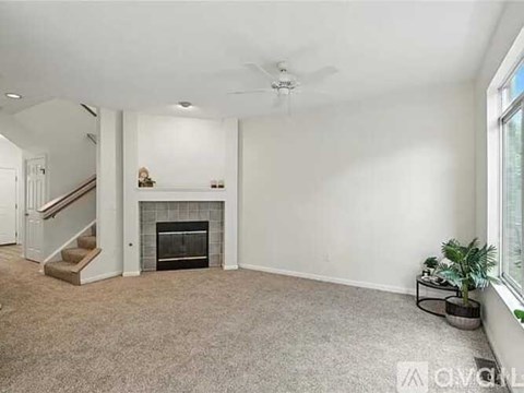 A living room with a fireplace and a ceiling fan.