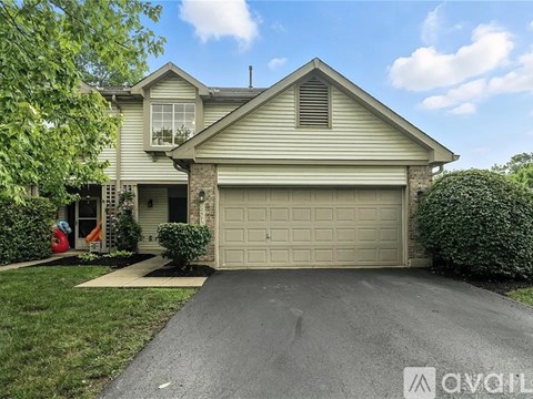 A house with a garage and a driveway in front.