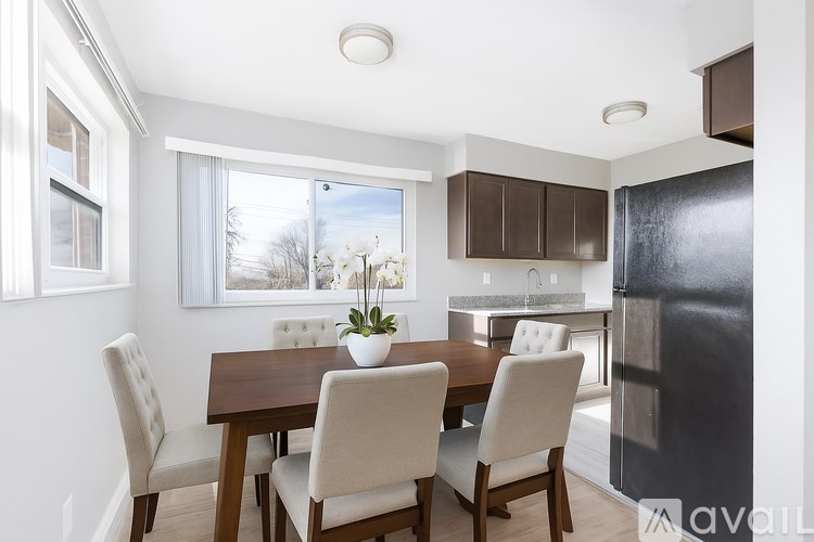 A kitchen with white appliances and wooden floors.