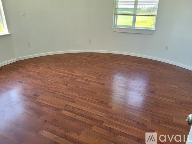 A room with wooden flooring and a window.