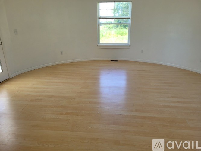 A room with wooden flooring and a window.