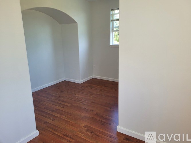 A room with wooden flooring and white walls.
