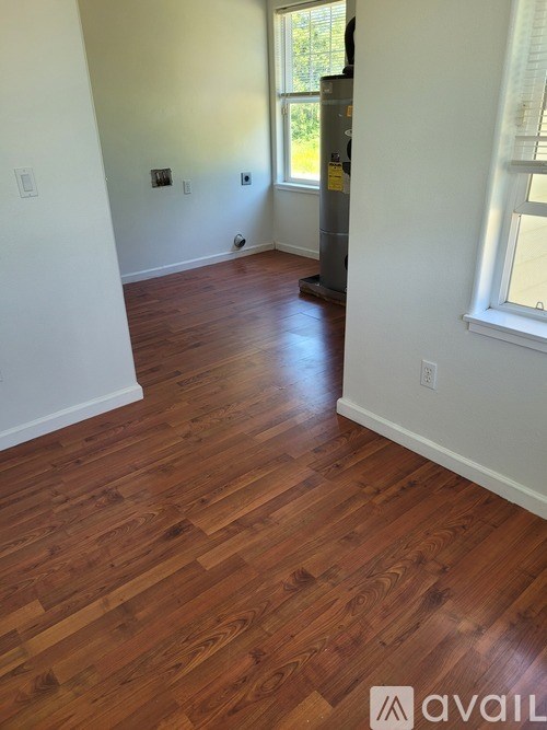 A room with wooden flooring and a window.
