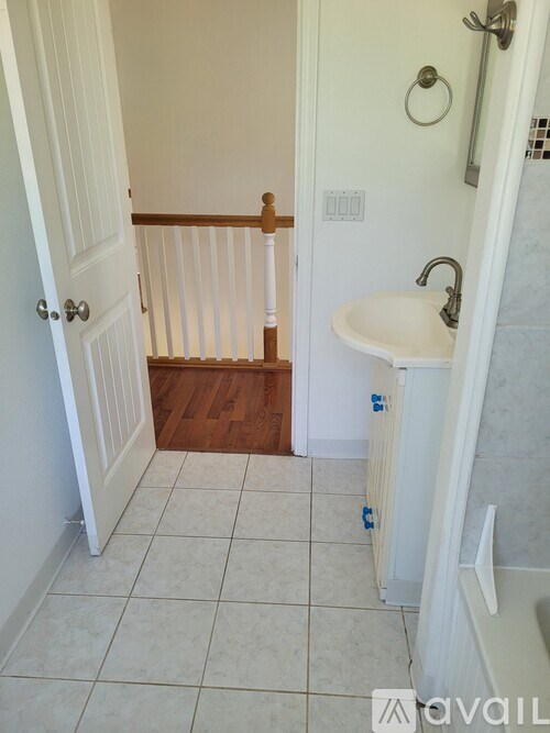 A bathroom with a white sink and a white door.