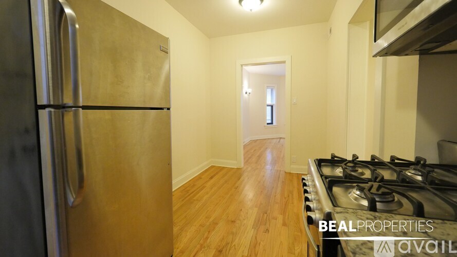 A kitchen with a stainless steel refrigerator and a stainless steel gas stove.