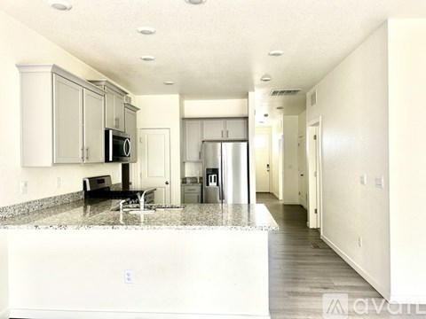 A kitchen with a granite countertop and stainless steel appliances.