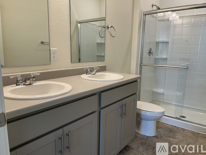 A bathroom with a toilet, sink, and shower.