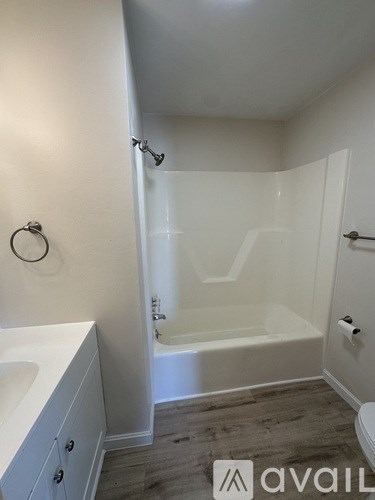 A bathroom with a tub, sink, and toilet.