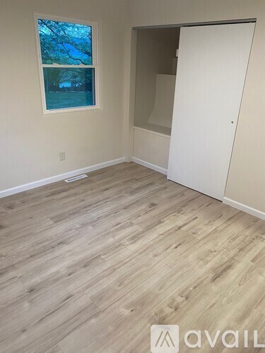 A room with a wooden floor and a window.