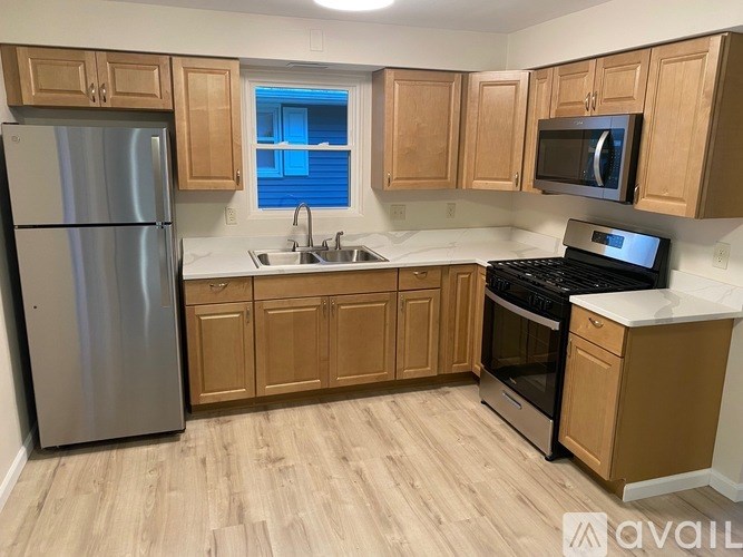 A room with wooden flooring and a window showing a red car outside.