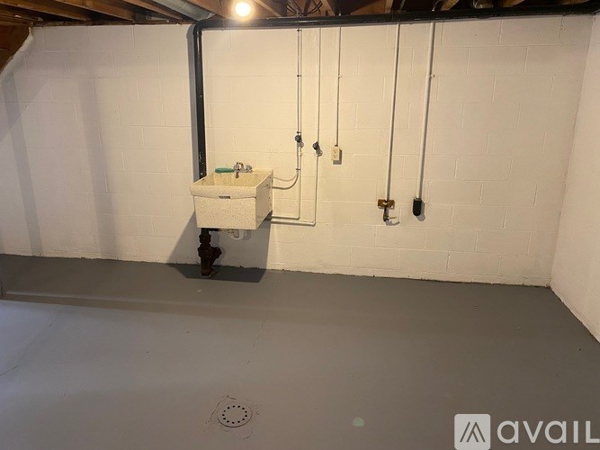 A bathroom with a white tiled wall and a white sink.