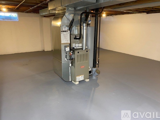 A large industrial air conditioning unit is installed in a room with a grey floor and white walls.