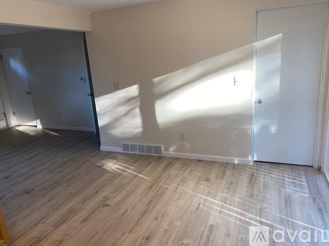 A room with wooden flooring and a large window.