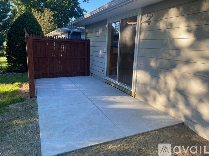 A house with a brown gate and a white fence.
