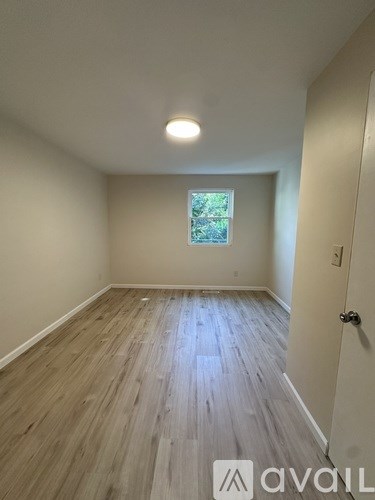 A room with wooden flooring and a window.