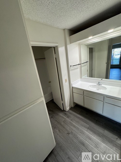 A bathroom with a sink, mirror, and a white door.