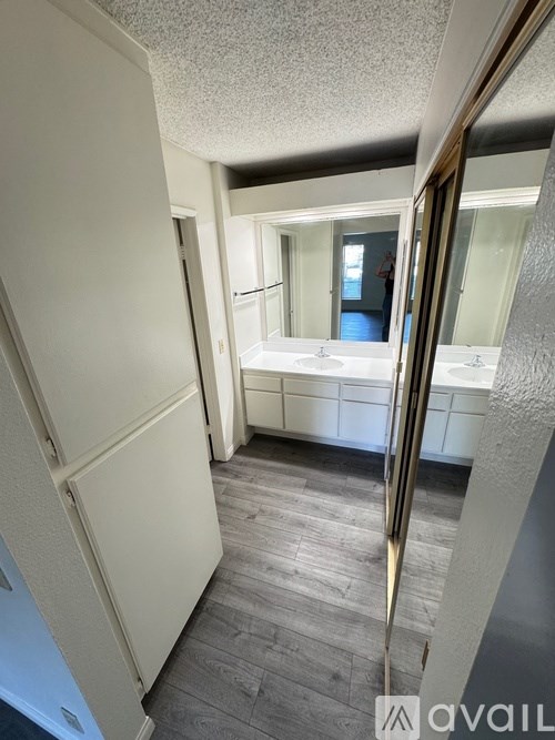 A bathroom with a white door and a mirror.