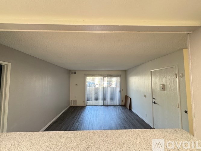A room with a bed in the foreground and a sliding door leading to a balcony.