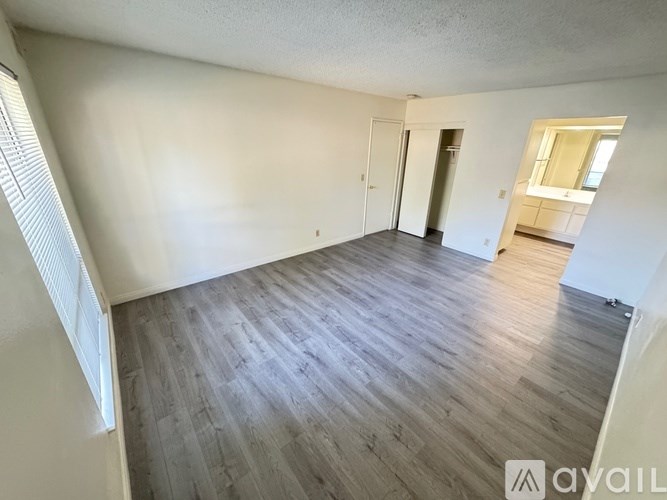 A room with wooden flooring and white walls.