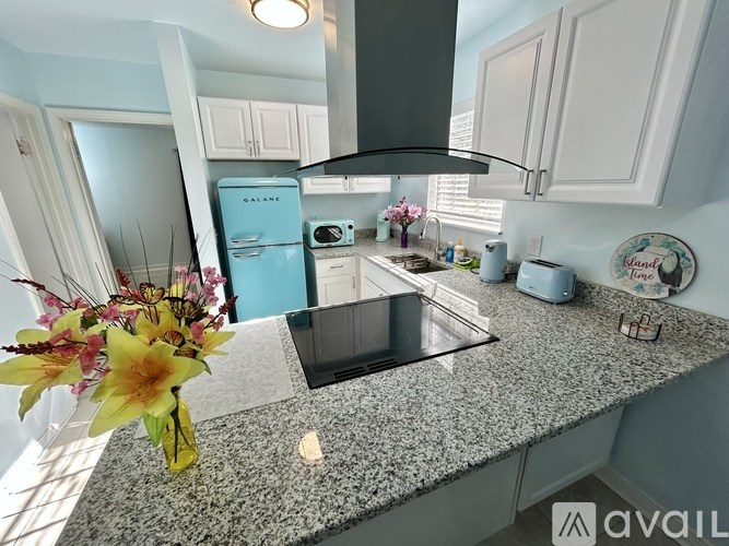 A kitchen with a granite countertop and a blue fridge.