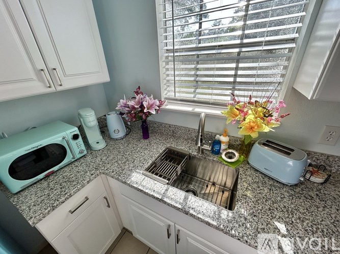 A kitchen with a sink, toaster, and microwave.