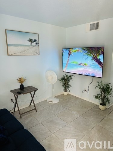 A living room with a flat screen TV mounted on the wall.