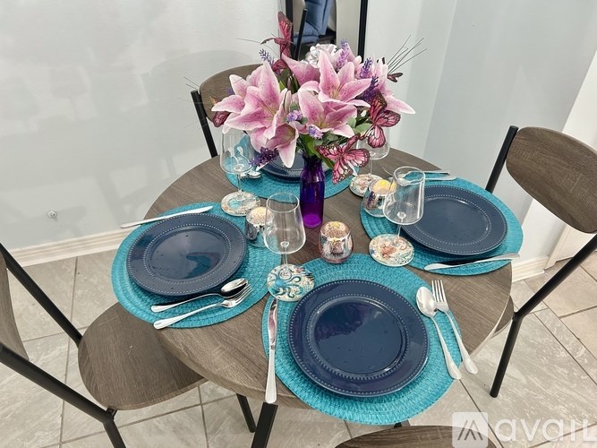 A table set with blue plates and a vase of flowers.