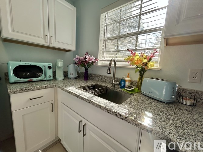 A kitchen with a sink, toaster, and microwave.