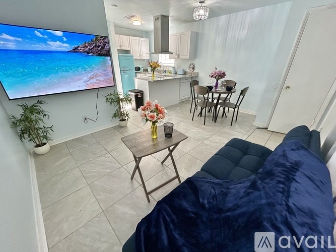 A living room with a flat screen TV mounted on the wall.