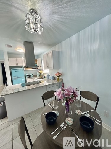 A modern kitchen with a dining table set for two.