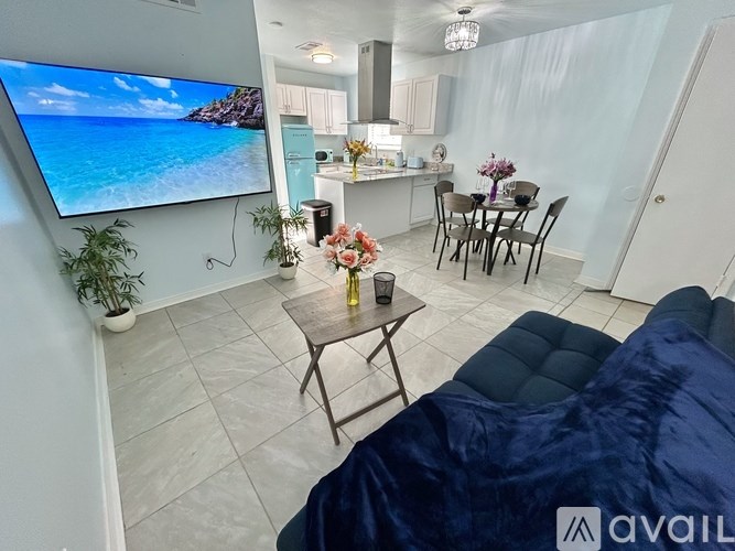 A living room with a large TV displaying a beach scene.