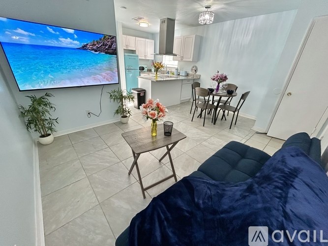 A living room with a flat screen TV displaying a beach scene.