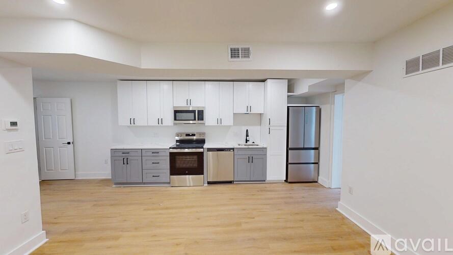 A kitchen with white cabinets and a wooden floor.