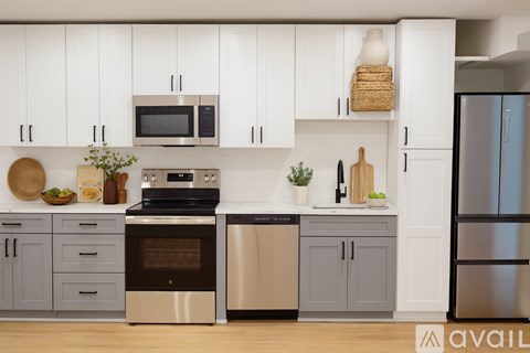 A kitchen with white cabinets and a wooden floor.
