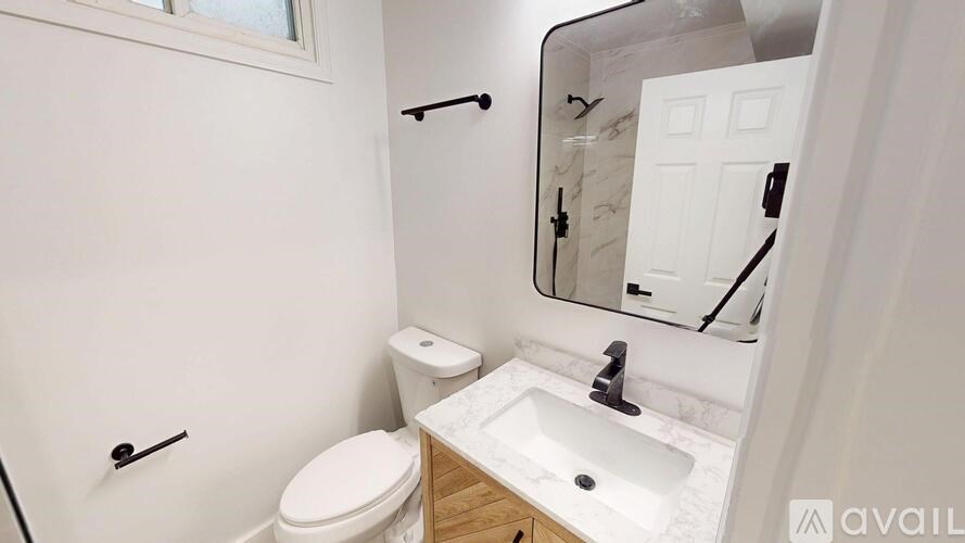 A white toilet sits next to a sink in a small bathroom.