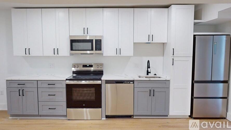 A kitchen with white cabinets and a variety of appliances.
