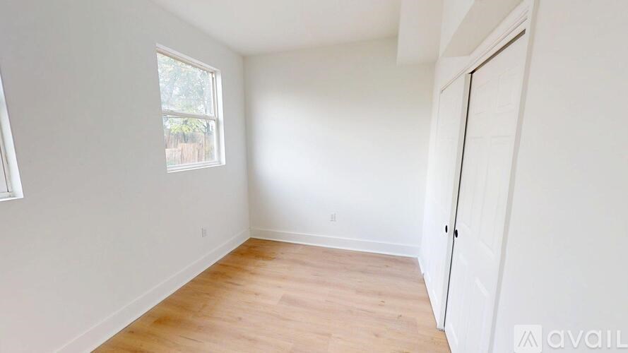 A room with a window and wooden flooring is available for rent.