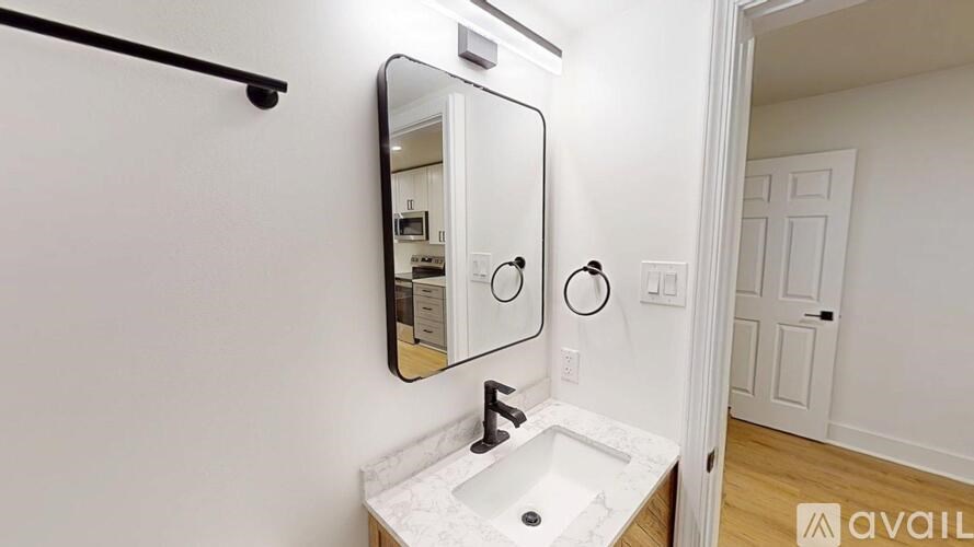 A bathroom with a sink, mirror, and a black bar.