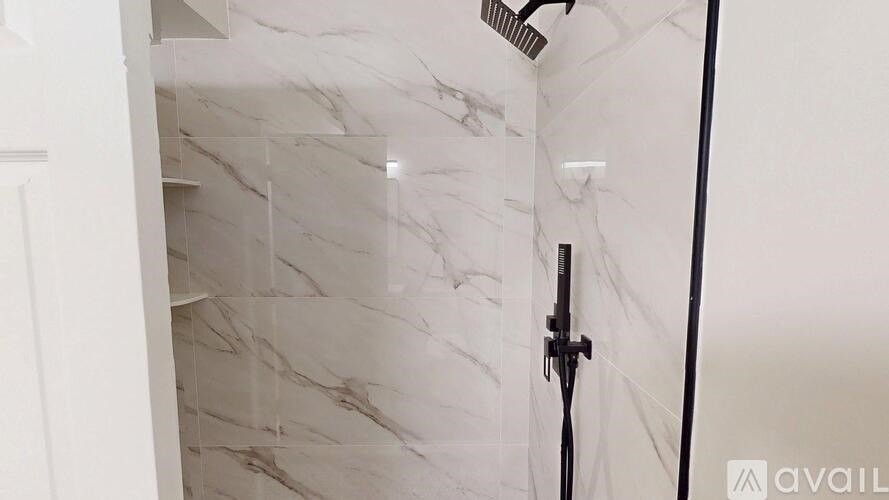 A white marble bathroom with a shower.